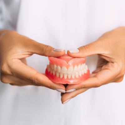 Lady presents viewer with dentures