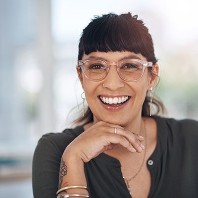 a woman with glasses smiling