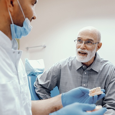 Removable implant dentures pictured against neutral background